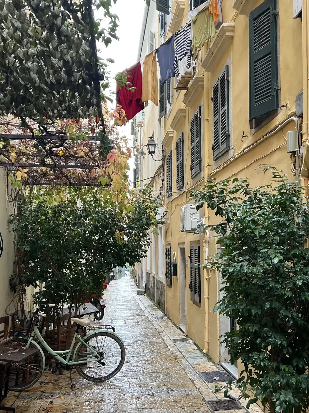 Venetian alley with bicycle, laundry overhead, yellow buildings
